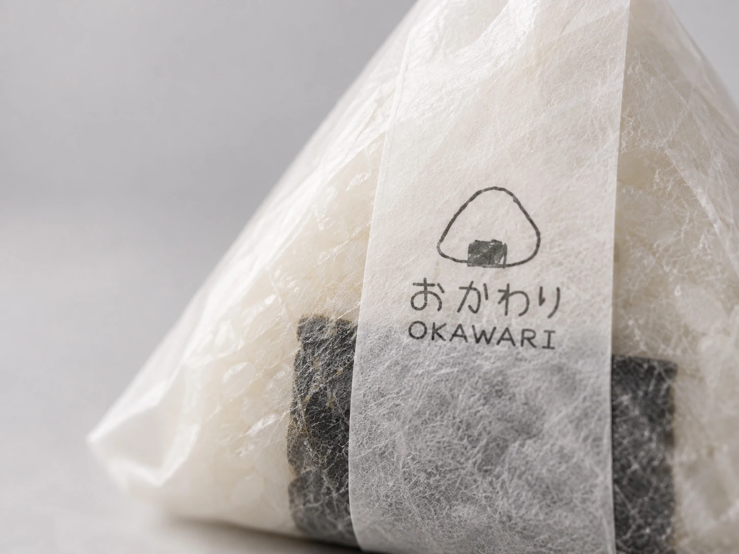 The textured paper wrapping of an OKAWARI rice ball