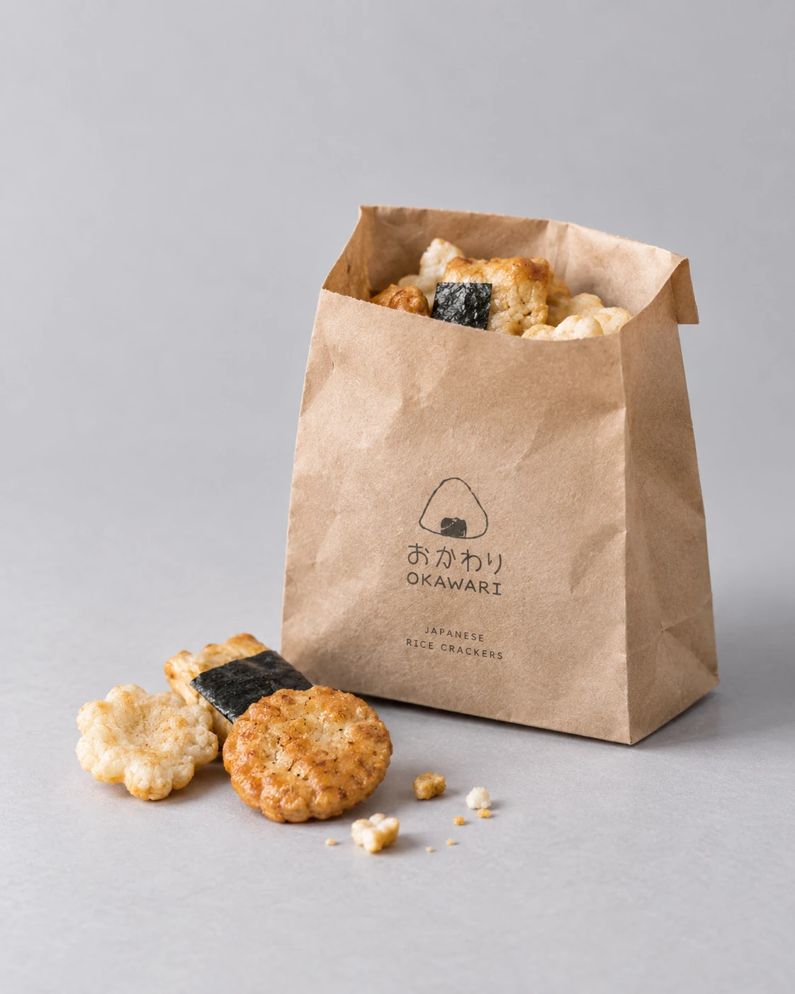 A kraft paper bag filled with assorted Japanese rice crackers
