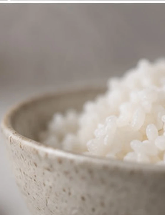 A close-up of warm Japanese rice in a ceramic bowl